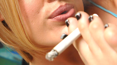 Girl smokes cigarette with toes and foot